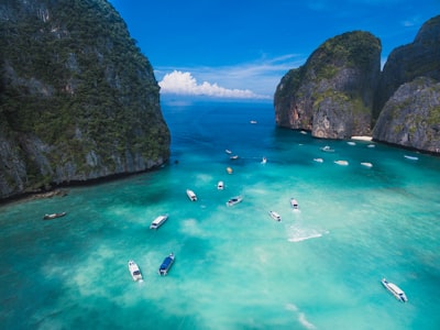 Boats on the turquoise water of Maya Bay between limestone cliffs in Thailand