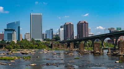 a bridge over a river with a city in the background