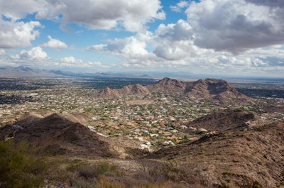 a view of a city and mountains from a hill