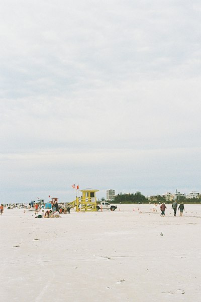 A group of people standing on top of a sandy beach