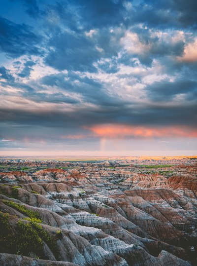 the sun is setting over the rocky terrain