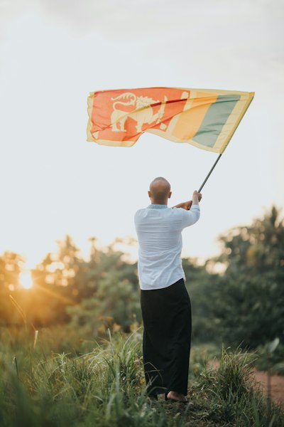 a man holding a flag while standing in a field