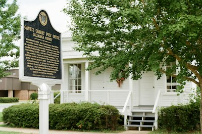 Historical marker sign in front of a white building