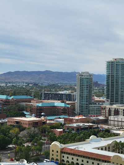 a view of a city with tall buildings and mountains in the background