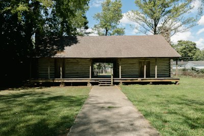 a wooden building with a grass yard