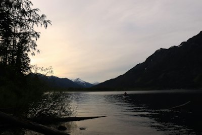 a person in a body of water with mountains in the background