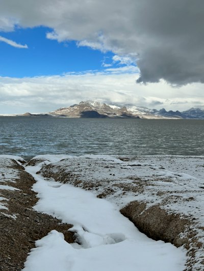 a snow covered beach with a mountain in the background