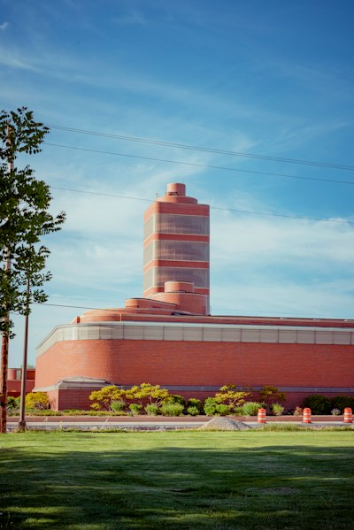 brown and white concrete building near green trees under blue sky during daytime